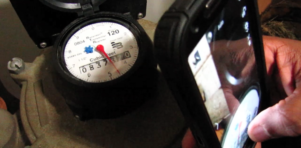 Phone photographing the dial of a home water meter to collect utility data